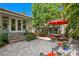 Charming outdoor patio with brick pavers, seating, and a vibrant red umbrella at 2421 Brevard Ne Rd, St Petersburg, FL 33704
