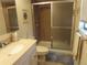 Bathroom featuring a tiled walk-in shower with sliding doors and a vanity with a cream-colored countertop at 2555 Royal Pines Cir # A, Clearwater, FL 33763