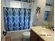 Bathroom with blue patterned shower curtain, vanity with a sink, toilet, and tiled walls at 2555 Royal Pines Cir # A, Clearwater, FL 33763