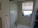 Bathroom featuring a tiled tub/shower combination with updated fixtures and a window for natural light at 2555 Royal Pines Cir # A, Clearwater, FL 33763