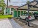 Carport with a beige Mini Cooper parked in front of green storage lockers and the building at 2555 Royal Pines Cir # A, Clearwater, FL 33763