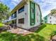 Two-story exterior elevation featuring well-maintained lawn and tropical landscaping at 2555 Royal Pines Cir # A, Clearwater, FL 33763