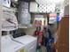 Laundry room with washer, dryer, hot water tank, shelving and storage space at 2555 Royal Pines Cir # A, Clearwater, FL 33763
