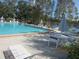 Community pool featuring a spacious deck area with lounge chairs and tables for relaxing by the water at 2555 Royal Pines Cir # A, Clearwater, FL 33763