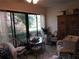 Enclosed sunroom with glass table and wicker furniture offering natural light and views of the surrounding landscape at 2555 Royal Pines Cir # A, Clearwater, FL 33763