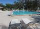 Community swimming pool with lounge chairs for relaxing on the brick pool deck at 2555 Royal Pines Cir # A, Clearwater, FL 33763