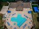 Aerial view of the community pool with lounge chairs, tables, umbrellas and recreation areas at 2629 Timacqua Dr, Holiday, FL 34691