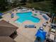 Aerial view of community pool featuring a clover-shape design, lounge chairs, and umbrellas at 2629 Timacqua Dr, Holiday, FL 34691
