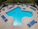 Aerial view showcasing the clover-shaped community pool with lounge chairs and a spa at 2629 Timacqua Dr, Holiday, FL 34691