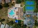 The aerial view shows a swimming pool, tennis court, clubhouse, parking lot, and playground in the community at 2629 Timacqua Dr, Holiday, FL 34691