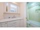 Bright bathroom with a marble vanity top, soft-close drawers, and a shower-tub combo at 2629 Timacqua Dr, Holiday, FL 34691