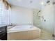 Bright bathroom features a soaking tub and glass-enclosed shower, creating a spa-like retreat at 2629 Timacqua Dr, Holiday, FL 34691