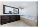 Bathroom featuring dual sinks, a large mirror, an oversized tub, and tile floors at 2629 Timacqua Dr, Holiday, FL 34691