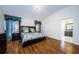 Spacious bedroom with hardwood floors, a large bed, and curtains with access to the bathroom at 2629 Timacqua Dr, Holiday, FL 34691