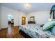Bedroom with hardwood floors, a large bed, and access to the hallway and closet space at 2629 Timacqua Dr, Holiday, FL 34691