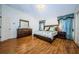 Well-lit bedroom with hardwood floors, a large bed, and matching nightstands and dressers at 2629 Timacqua Dr, Holiday, FL 34691