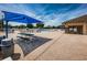 Community pool area featuring blue umbrellas, tables, and lounge chairs, perfect for relaxation at 2629 Timacqua Dr, Holiday, FL 34691