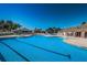 Large community pool featuring lane markers, sun loungers, and a surrounding brick patio at 2629 Timacqua Dr, Holiday, FL 34691