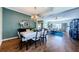 Open concept dining room adjacent to the living room with hardwood floors and a modern chandelier at 2629 Timacqua Dr, Holiday, FL 34691