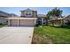 Attractive two-story house boasting a lush green lawn and a spacious three-car garage at 2629 Timacqua Dr, Holiday, FL 34691