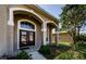 Welcoming front door framed by decorative archways and lush landscaping at 2629 Timacqua Dr, Holiday, FL 34691