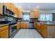 Bright kitchen with wood cabinets, granite countertops, stainless steel appliances, and mosaic backsplash at 2629 Timacqua Dr, Holiday, FL 34691