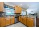 Kitchen featuring wood cabinets, granite countertops, a breakfast bar, and stainless steel appliances at 2629 Timacqua Dr, Holiday, FL 34691