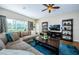 Bright living room boasts a large window, ceiling fan, and hardwood flooring at 2629 Timacqua Dr, Holiday, FL 34691