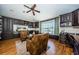 Office featuring custom built-in shelving and desk, hardwood floors, ceiling fan, and a comfortable seating area at 2629 Timacqua Dr, Holiday, FL 34691