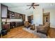 Office featuring custom built-in shelving and desk, hardwood floors, a ceiling fan, and a seating area with a table at 2629 Timacqua Dr, Holiday, FL 34691