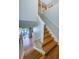 Hardwood staircase with white railing leads to the upper level, providing access to the bedrooms and other living spaces at 2629 Timacqua Dr, Holiday, FL 34691