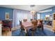 Warm dining area featuring a table set for six, adjacent to the kitchen with sheer curtains and natural light at 2805 Olavet Ct, Valrico, FL 33596