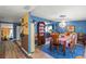 Open dining area with a colorful rug, unique chandelier, and seamless view to the kitchen with bright finishes at 2805 Olavet Ct, Valrico, FL 33596