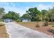 View of the home with a driveway leading up to a detached garage, surrounded by mature trees and greenery at 2805 Olavet Ct, Valrico, FL 33596