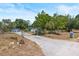 View of the home with a long driveway leading up to a detached garage and a chain-link fenced yard at 2805 Olavet Ct, Valrico, FL 33596