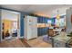 Bright kitchen with blue cabinets and white appliances, leading to a cozy living area at 2805 Olavet Ct, Valrico, FL 33596