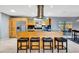 Bright kitchen featuring wood cabinetry, stainless steel appliances, a central island with seating, and a modern range hood at 3044 Golden Rain Dr, Sarasota, FL 34232
