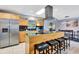 Stylish kitchen featuring a central island with bar stools, stainless steel appliances, and wood cabinetry at 3044 Golden Rain Dr, Sarasota, FL 34232