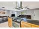 Open-concept kitchen and living area with a stainless steel range hood, wood cabinetry, and a cozy living space at 3044 Golden Rain Dr, Sarasota, FL 34232