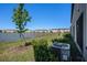 Backyard view with lake, green lawn, and A/C unit in view at 32091 S Pop Ash N Pl, San Antonio, FL 33576
