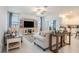 Bright living room with neutral tones and a ceiling fan is open to a modern, white kitchen at 32091 S Pop Ash N Pl, San Antonio, FL 33576