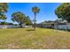 Large grassy backyard featuring mature trees and a pristine white fence at 3241 Brushwood Ct, Clearwater, FL 33761