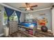 Cozy bedroom featuring a ceiling fan, a gray dresser, and unique wood-look flooring at 3241 Brushwood Ct, Clearwater, FL 33761