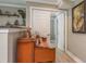 Hallway with neutral tones, beautiful hardwood floors, and stylish piano with interesting decorative shelves at 3241 Brushwood Ct, Clearwater, FL 33761