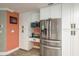 Bright kitchen with stainless steel refrigerator, white cabinets, and a view of the desk area at 3241 Brushwood Ct, Clearwater, FL 33761