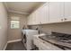 Spacious laundry room with white cabinets and a granite countertop at 3241 Brushwood Ct, Clearwater, FL 33761