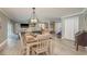 Bright living room featuring a modern farmhouse table, seating area, and light wood-look floors at 3241 Brushwood Ct, Clearwater, FL 33761