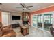Cozy living room features a stone fireplace and glass sliding doors to the lanai at 3241 Brushwood Ct, Clearwater, FL 33761
