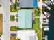 Aerial view showcases the home's backyard with a dock, along with a neighborhood canal and manicured landscaping at 3505 Seaway Dr, New Port Richey, FL 34652