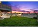 Sunset view of backyard featuring lush green lawn and a canal with boat docks creating a tranquil outdoor space at 3505 Seaway Dr, New Port Richey, FL 34652
